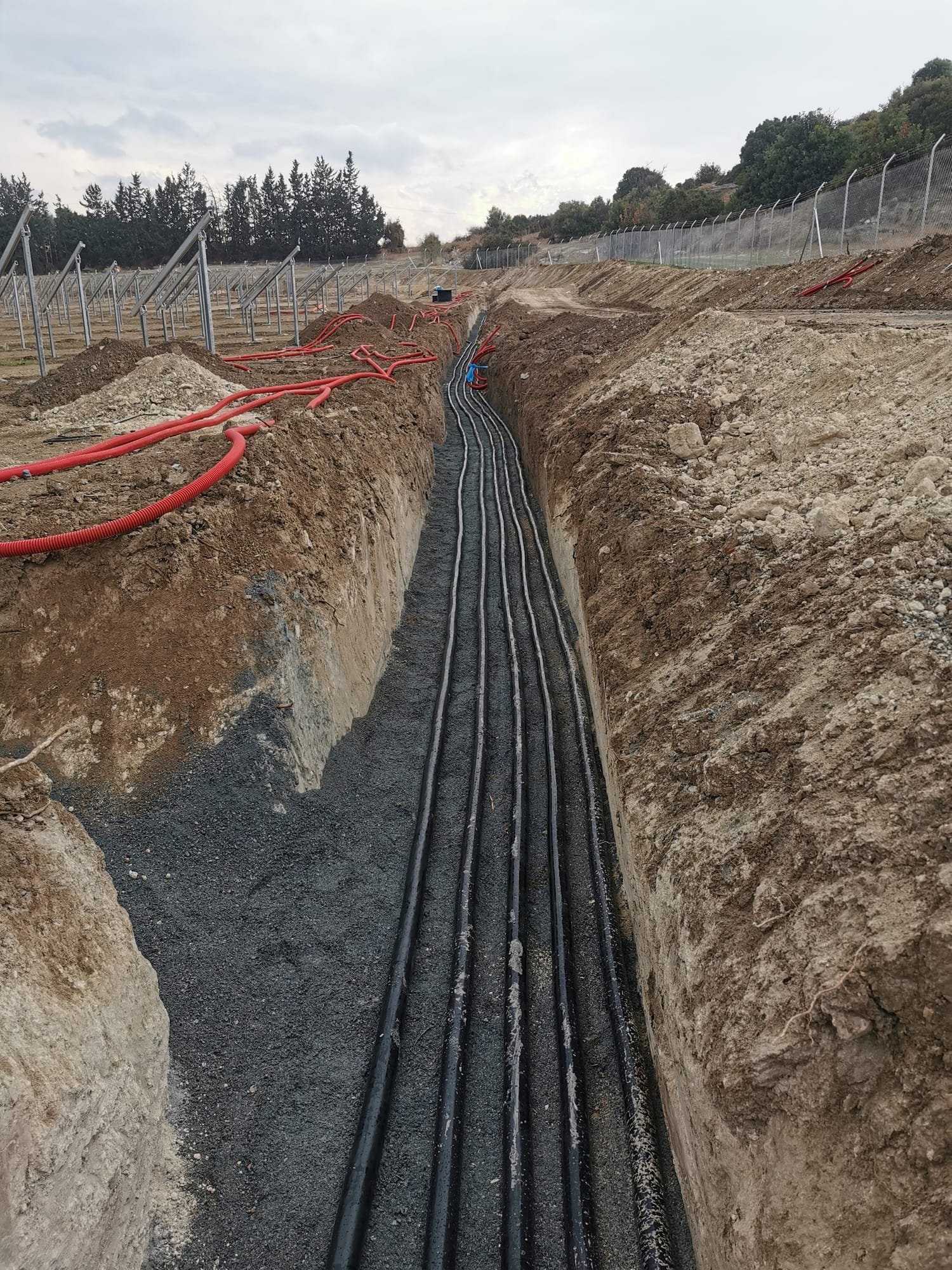 DC cable trench with conduits routed across a solar construction site in Cyprus
