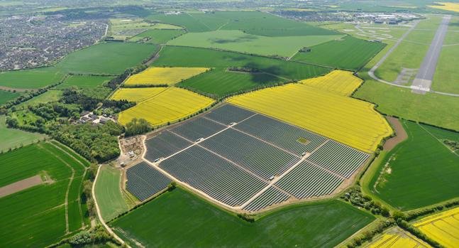 Aerial view of the Wiggin solar plant in the United Kingdom among green fields